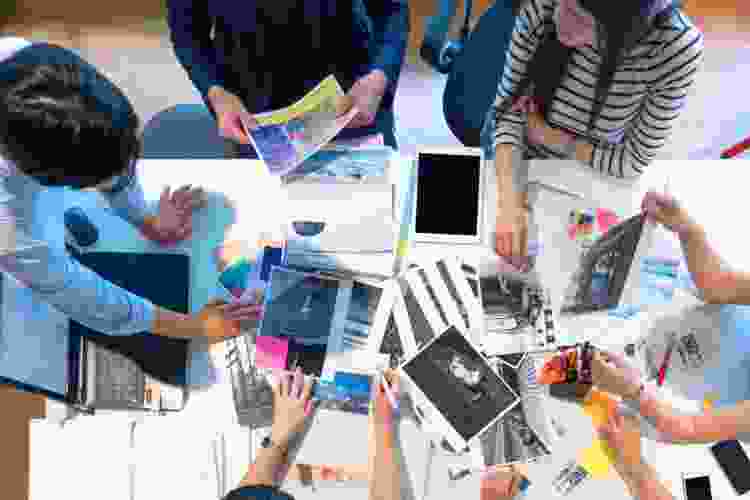 friends gathered around magazine cut outs on table