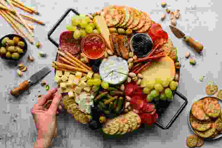 hand picking slice of cheese from charcuterie