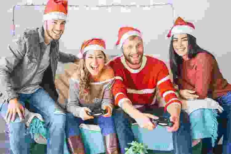 friends playing video games in Santa hats