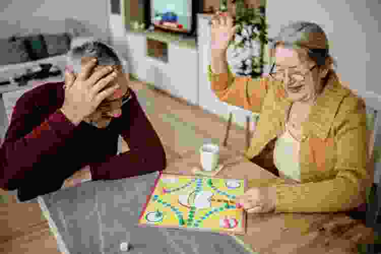 older couple playing board games on their kitchen table