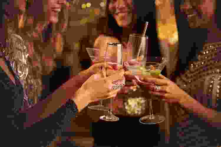 women in dresses cheersing cocktails