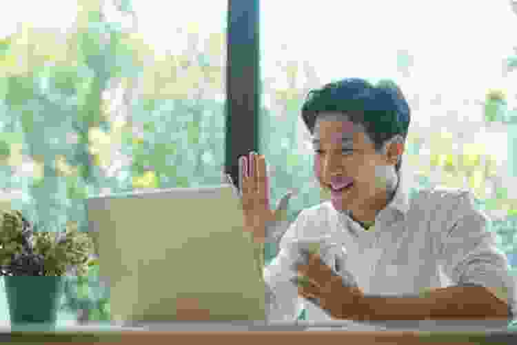 man drinking coffee while on virtual video call 