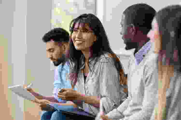 group of coworkers listening and taking notes during presentation