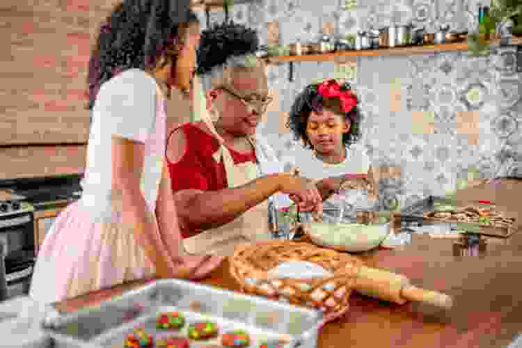 grandmother baking Christmas cookies with young grandchildren