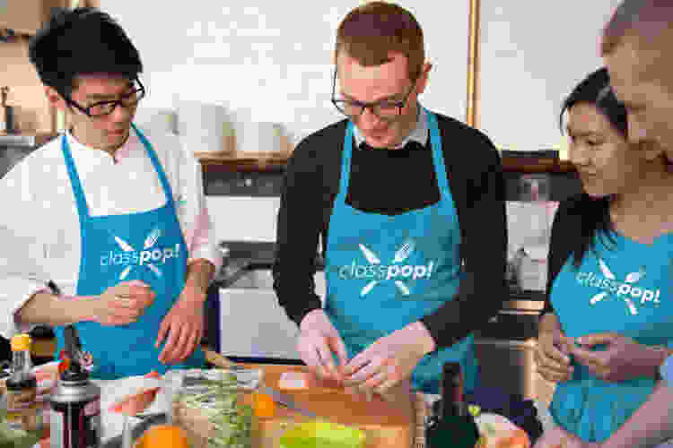 team members learning to cook together in cooking class