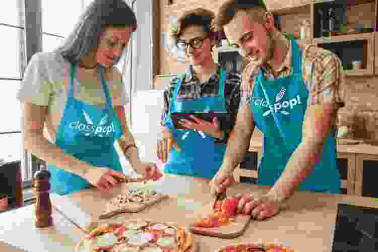 friends making pizza in cooking class