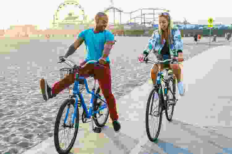 couple riding bikes together by the beach