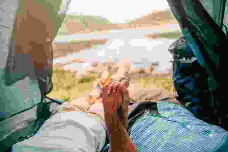 couple holding hands in camping tent