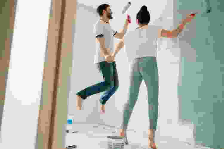 couple painting room wall together