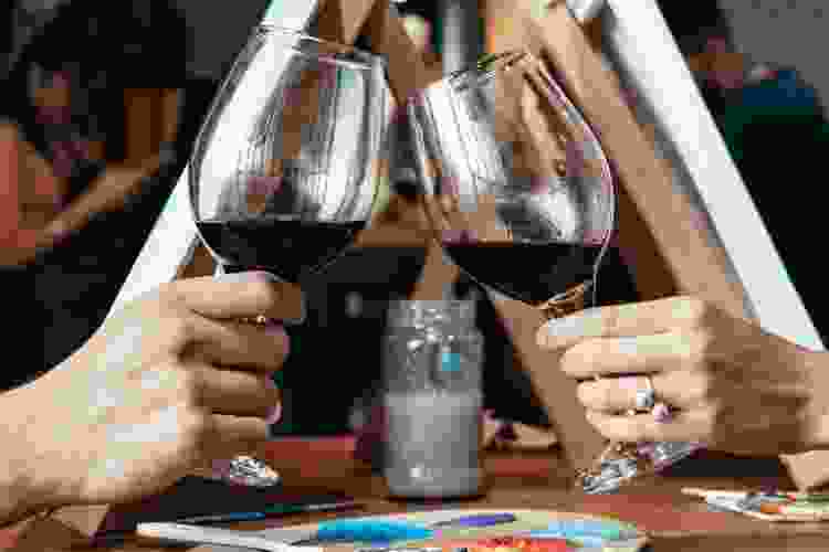 couple cheers wine at paint party