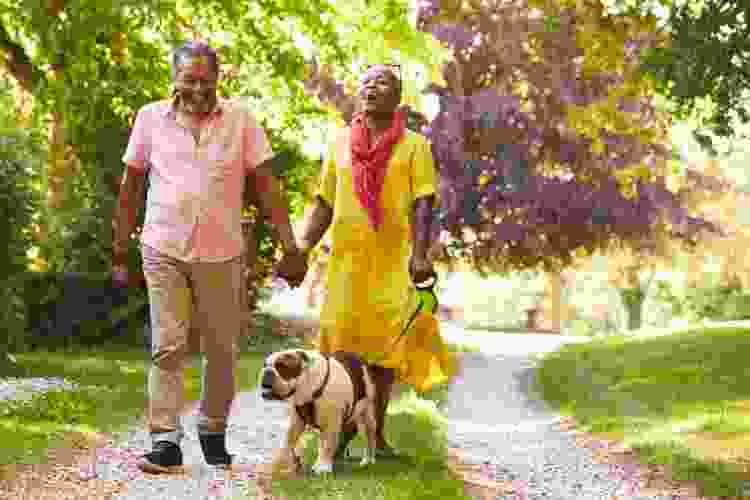 couple walking their dog through the park trail