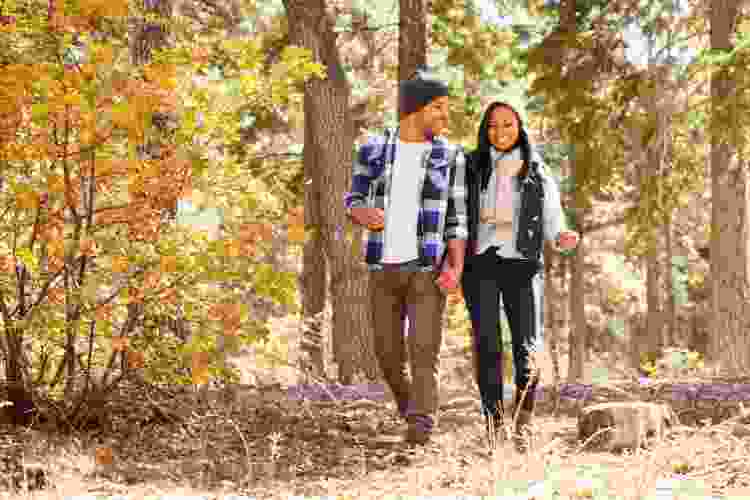 couple walking on trail through autumn forest