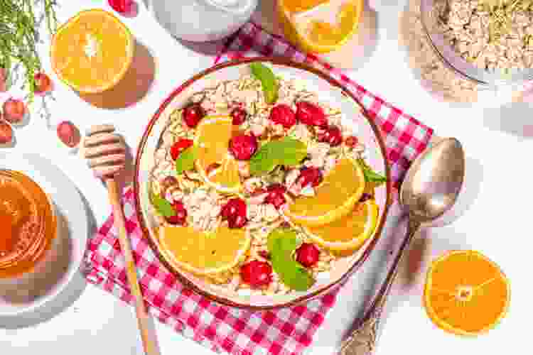 bowl of oatmeal with sliced oranges and cranberries