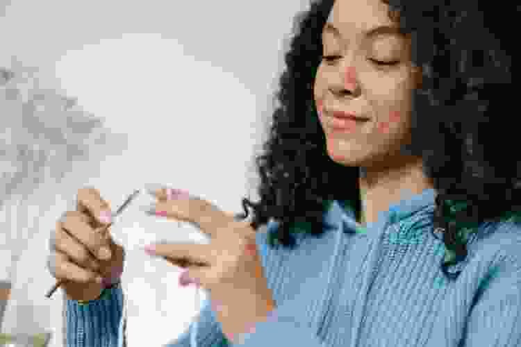 young woman crocheting white yarn