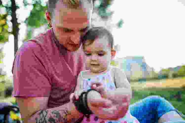 dad holding baby while wearing clay bead bracelets