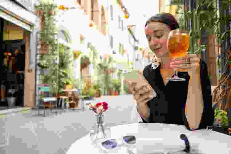 woman drinking wine alone at outdoor restaurant