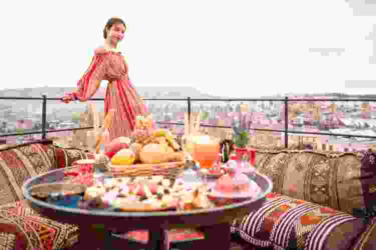 woman standing on rooftop by dinner table