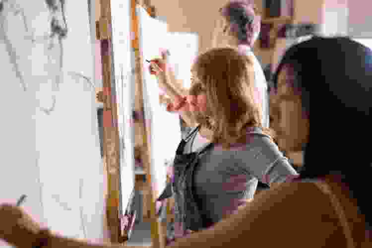 women sketching art in drawing class