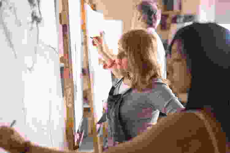 women drawing on canvas in drawing class