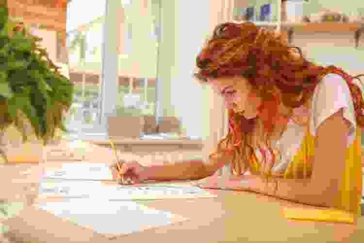 woman drawing sketches on desk