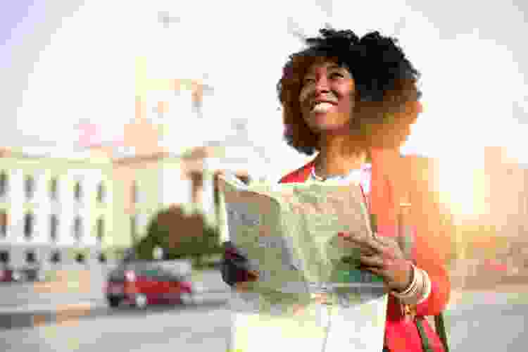 woman carrying map through European city