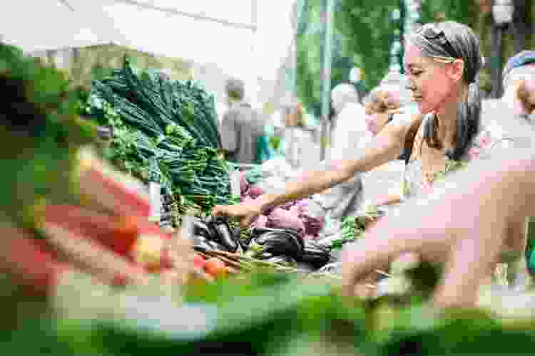 woman shopping for vegetables at the farmers market