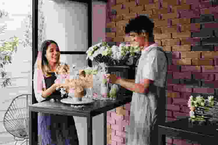 two people arranging bouquets of white flowers