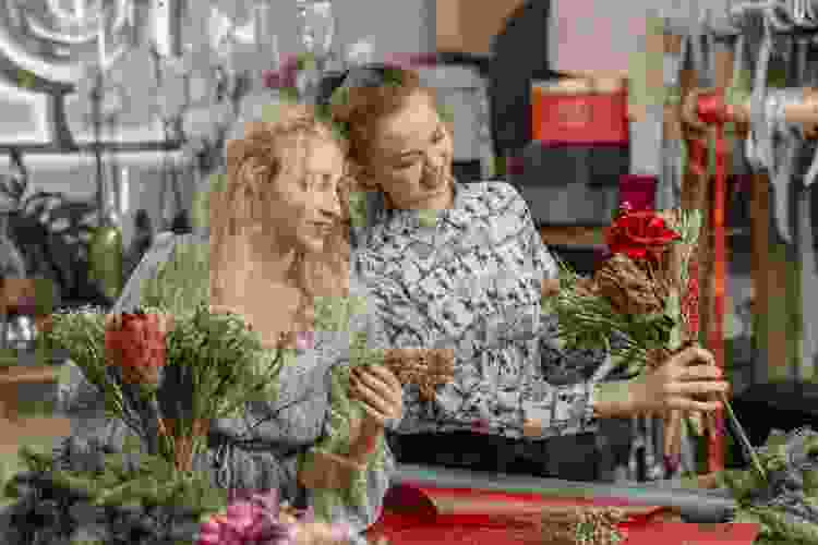 young women arranging flowers together