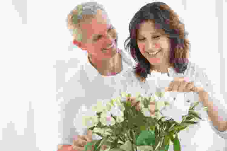 older couple arranging white flowers together