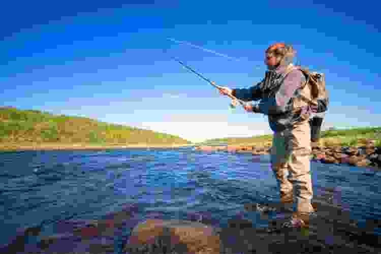 man fly fishing in river