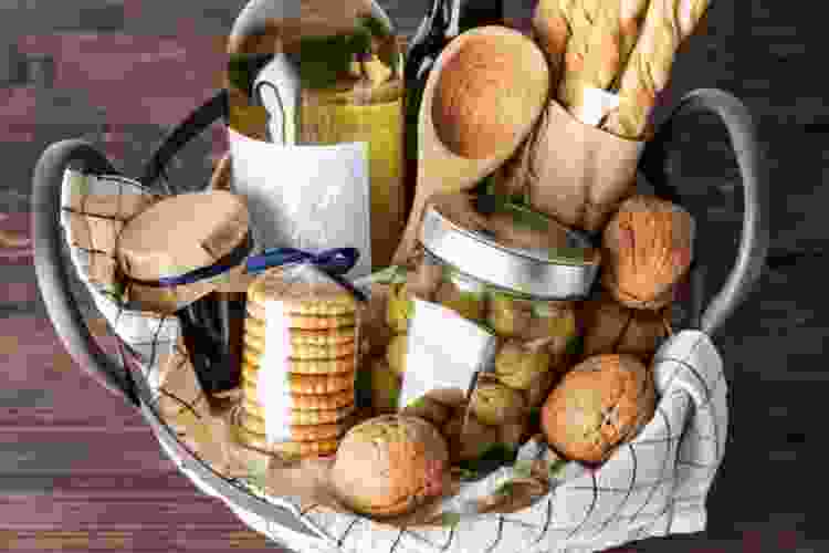 gift basket filled with bread, wine, cheese and other snacks