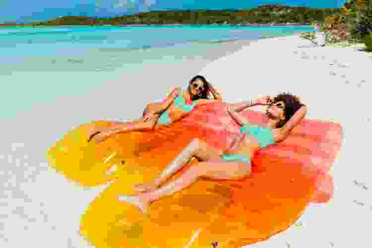 women lounging on inflatable at the beach