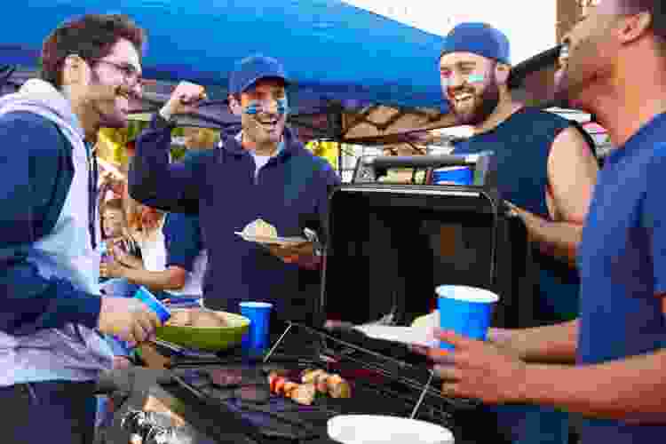 men barbecuing around tailgate