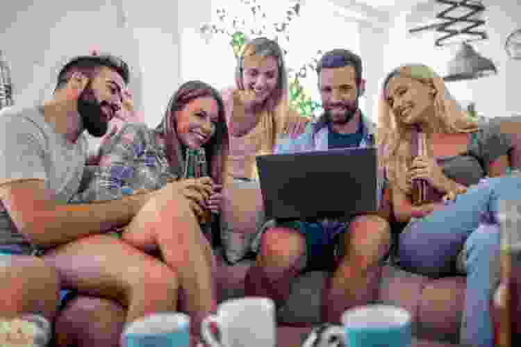 group of friends with laptop playing game 