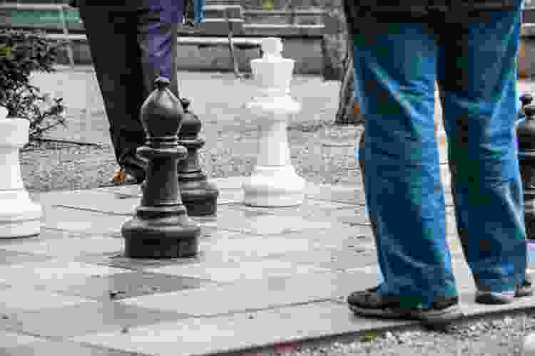 people walking on giant chess board