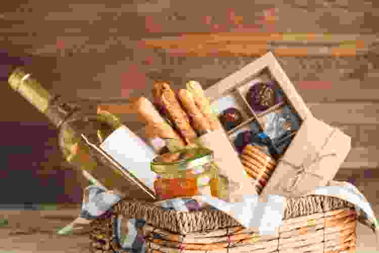 gift basket full of wine, cheese and other snacks