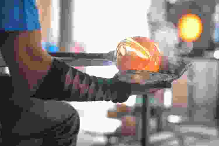 hand blowing orange glass art