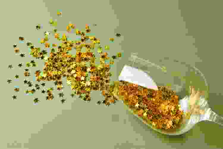 gold glitter stars spilling out of wine glass