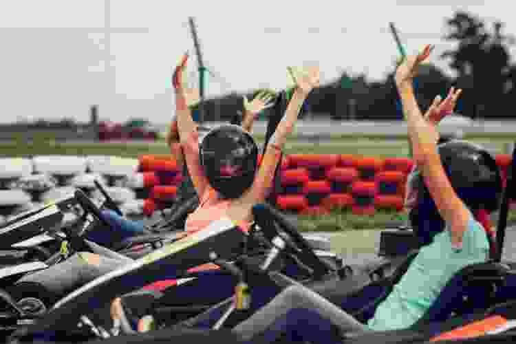 group of go kart racers with their hands in the air