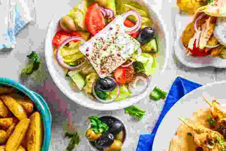 Greek salad and assorted Greek food on table