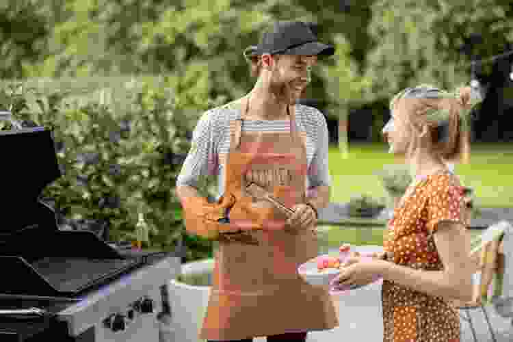 couple grilling in backyard