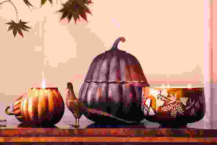 assorted pumpkin candles on a shelf