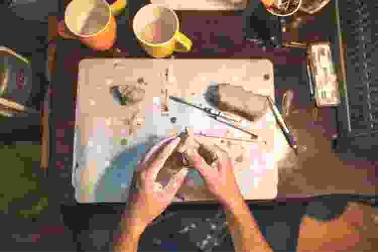 hands molding clay for hand building pottery