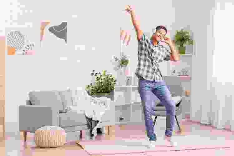 teen boy dancing in room wearing headphones 