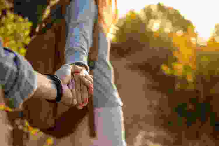 couple holding hands while hiking