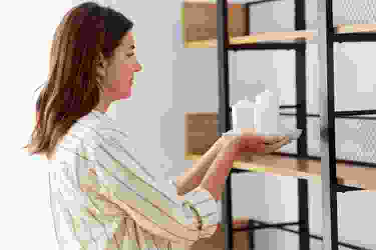 woman placing candles on shelf