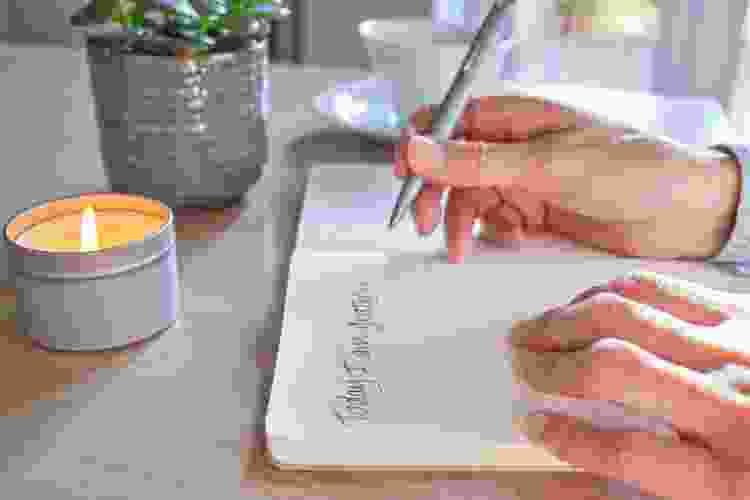 journaling by candle and plants