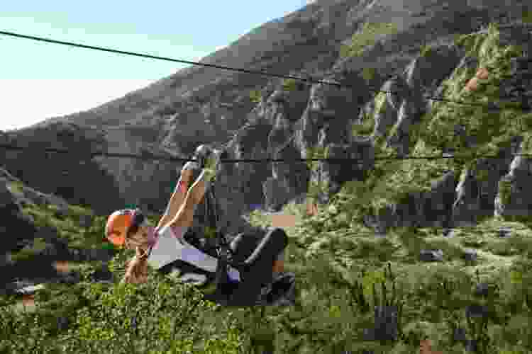 woman riding on zipline in California