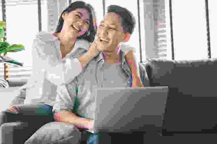 couple having fun while playing games on laptop