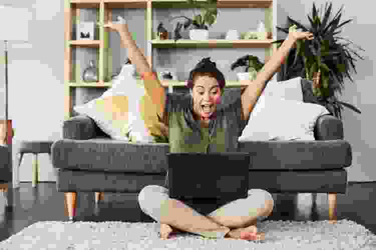 woman celebrating game win on laptop